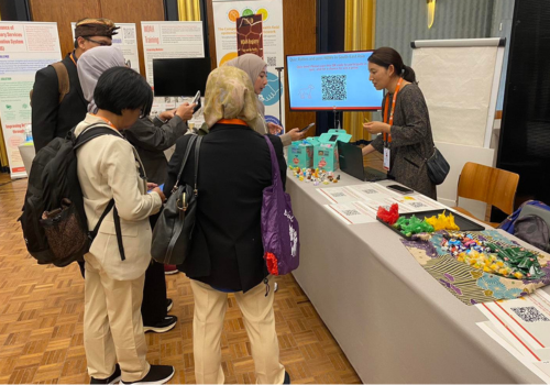Maho Urabe (WOAH RRAP) interacting with a group of visitors at the Regional Kiosk. The kiosk received around 100 visitors over the course of one day.